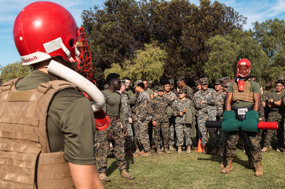 U.S. Marines Corps Chief Warrant Officer 2 Joshua Oakes, executive officer of Ammunition Company, left, competes with Lt. Cmdr. Jonathan Fowler, a company commander officer of Medical Logistics, both with 1st Supply Battalion, 1st Marine Logistics Group, in pugil sticks during a battalion field meet on Camp Pendleton, Nov. 22, 2022.  Marines and Sailors from different companies competed head-to-head in pugil sticks, burpee race, push-up race, tug-of-war, and tire flip race in order to win the battalion trophy. 1st Supply Battalion holds field meets to sustain camaraderie and healthy work relations. (U.S. Marine Corps photo by Lance Cpl. Kristy Ordonez Maldonado)