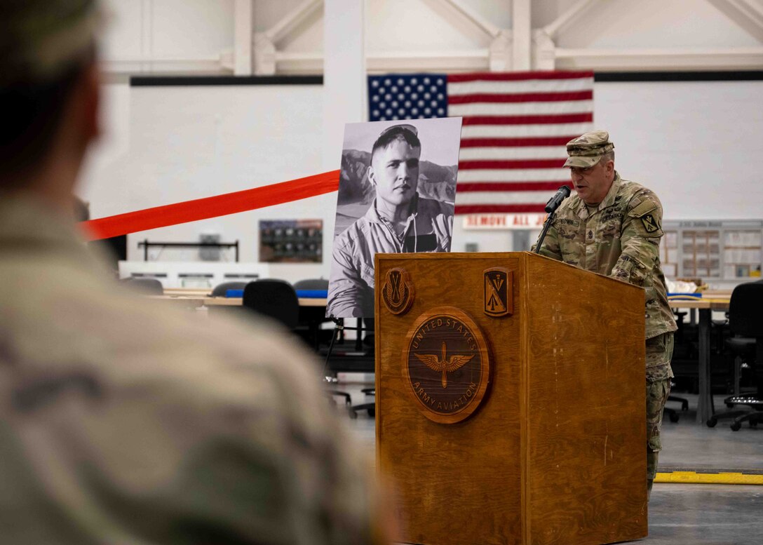 A U.S. Army leader speaks at a podium during a building dedication ceremony.