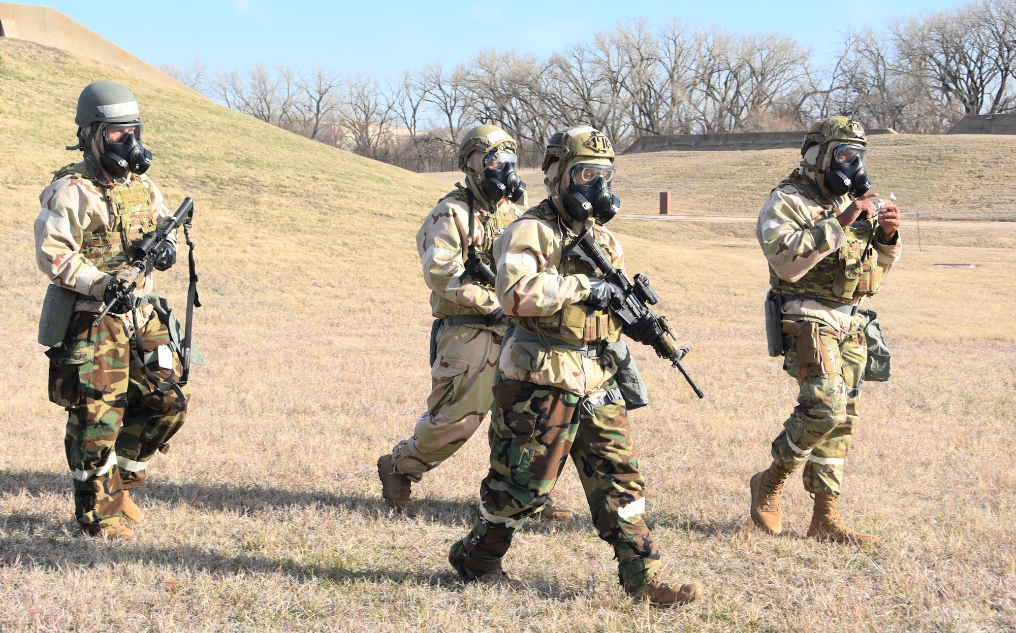 Four Airmen from the 931st Civil Engineer Squadron rush to their tent as part of routine readiness exercise March 5