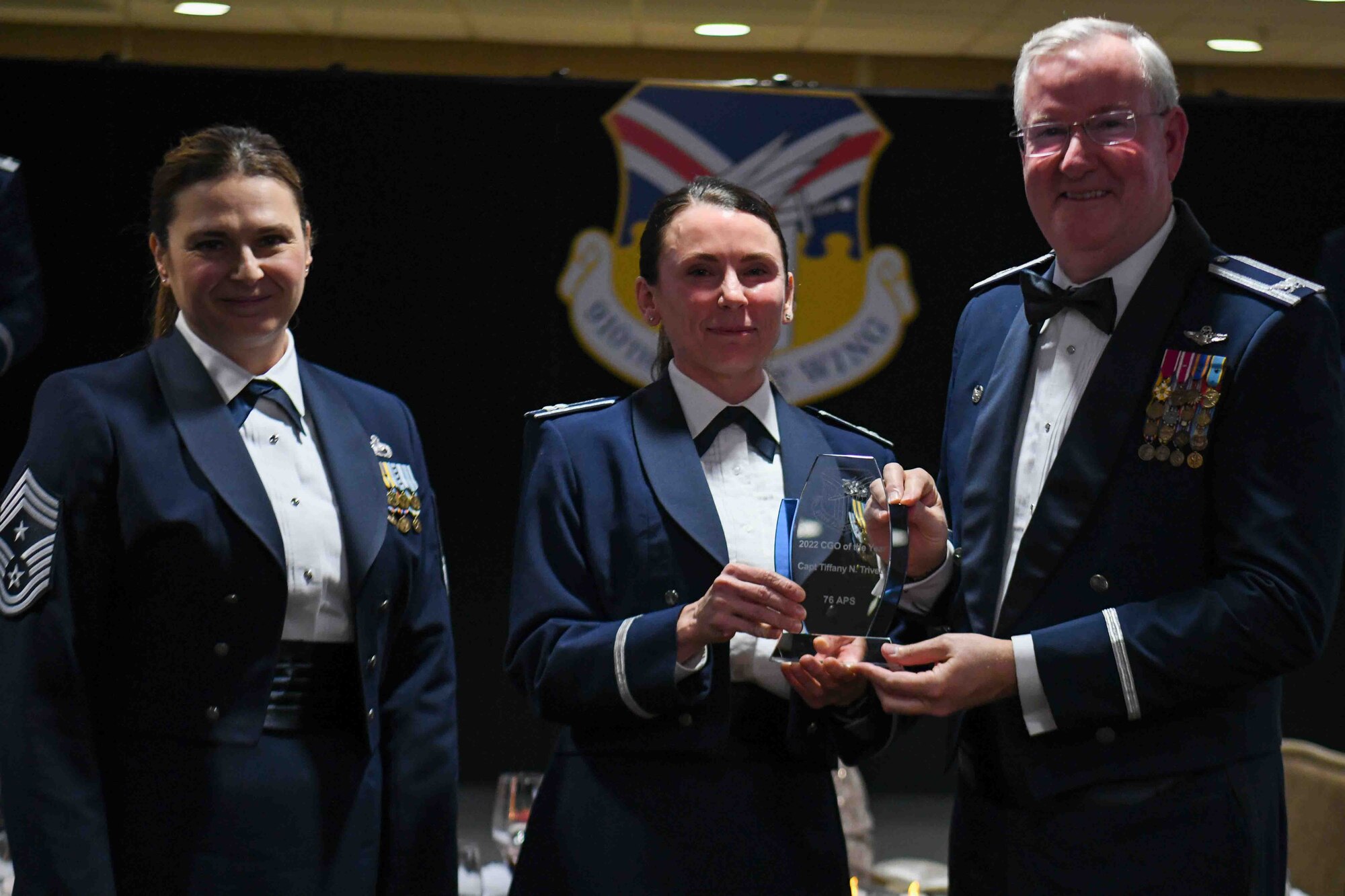 Capt. Tiffany Trivett (center), operations officer assigned to the 76th Aerial Port Squadron, receives the 2022 Company Grade Officer of the Year award from 910th Airlift Wing Commander Col. Jeff Van Dootingh (right) and 910th AW Command Chief Master Sgt. Jennifer McKendree (left), during the unit’s annual awards banquet, March 4, 2023, at Youngstown Air Reserve Station, Ohio.