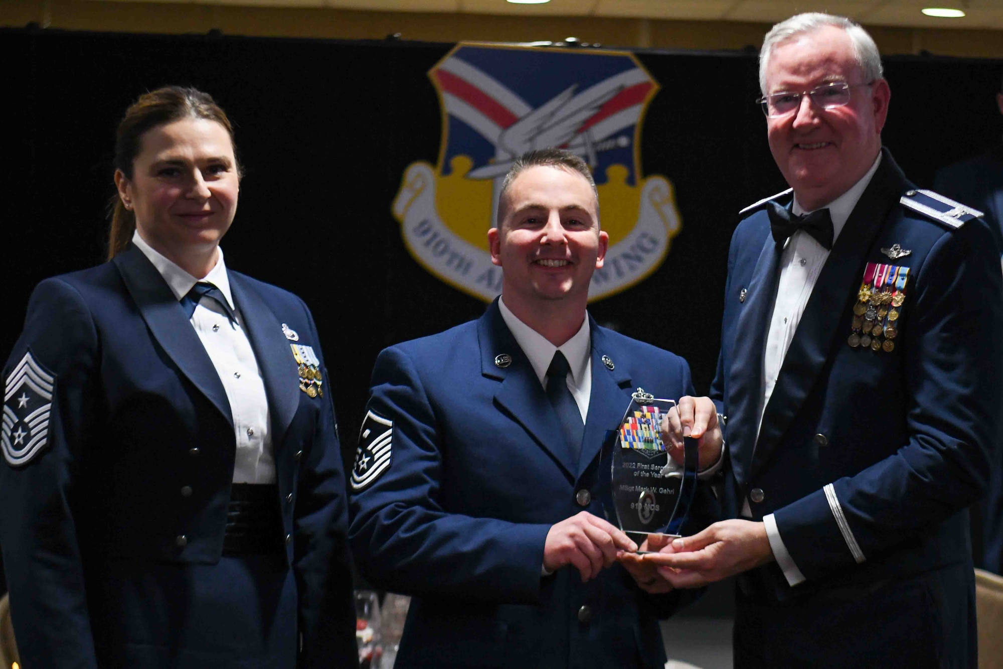 Master Sgt. Mark Gehri, first sergeant assigned to the 910th Medical Squadron, receives the 2022 First Sergeant of the Year award from 910th Airlift Wing Commander Col. Jeff Van Dootingh (right) and 910th AW Command Chief Master Sgt. Jennifer McKendree (left), during the unit’s annual awards banquet, March 4, 2023, at Youngstown Air Reserve Station, Ohio.