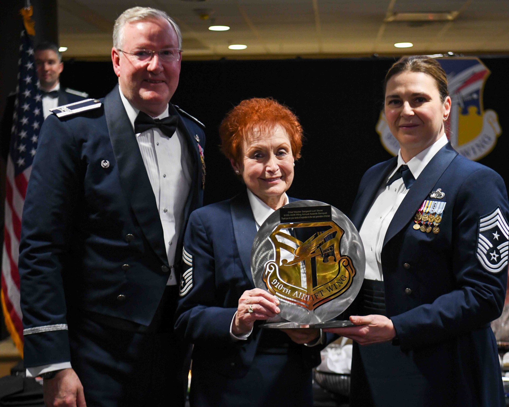 910th Airlift Wing Commander Col. Jeff Van Dootingh (left) and 910th Airift Wing Command Chief Master Sgt. Jennifer McKendree (right), present retired Chief Master Sgt. Lori Stone (center), guest speaker at the 910th Airlift Wing’s annual awards banquet, with a wing shield plaque, March 4, 2023, for her prior service and continued support of Youngstown Air Reserve Station, Ohio.