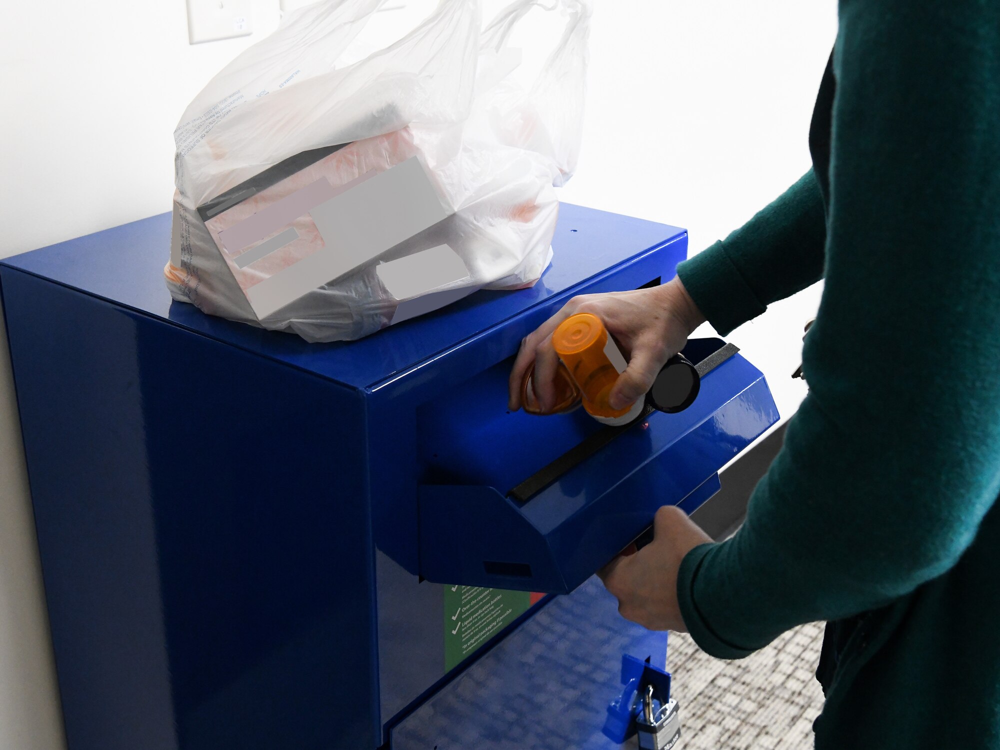 Person dropping medicine bottles into a box