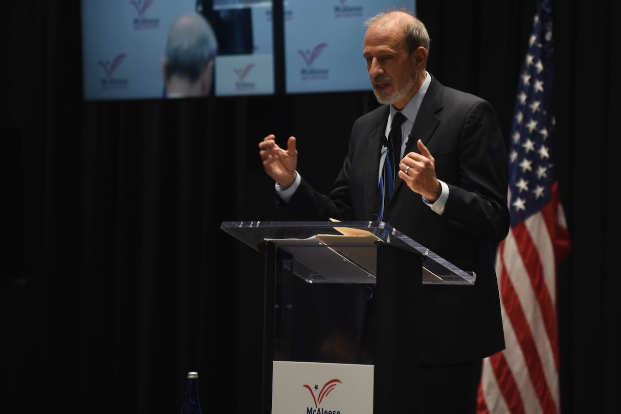 A man speaks from behind a lectern.