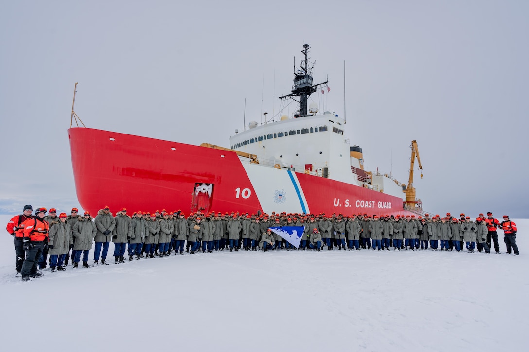 Coast Guard Cutter Polar Star’s (WAGB 10) crew poses for a group photo in front of the cutter in Antarctica, Jan. 2, 2023. To support Operation Deep Freeze 2023 the Polar Star cuts a channel through the ice to allow the ice-strengthened resupply ships to reach McMurdo Station. (U.S. Coast Guard photo by Petty Officer 3rd Class Aidan Cooney)