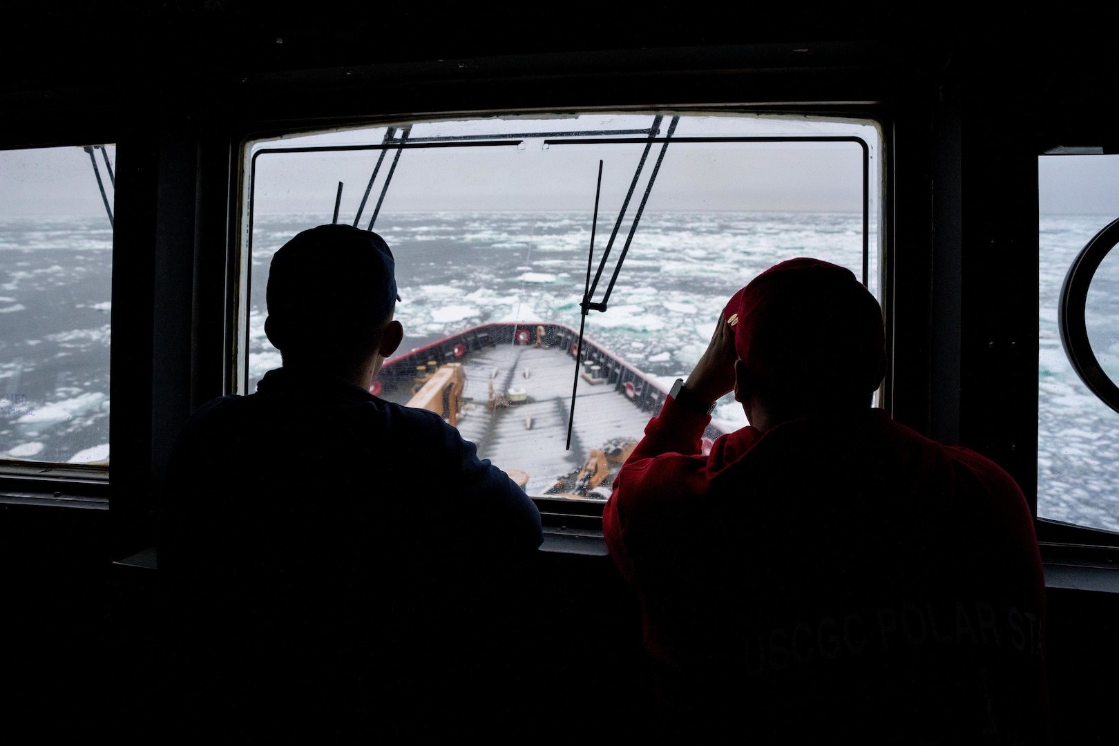 Lt. Cmdr. Donald Rudnickas, a member of the Coast Guard Icebreaking program temporarily assigned to Coast Guard Cutter Polar Star (WAGB 10), and Ensign Jonathan Kattnig, the information technology officer on the Polar Star, look out across the ice in the Southern Ocean, Dec. 25, 2022. The Coast Guard Cutter Polar Star first arrived in the pack ice on Christmas Day. Polar Star is en route to Antarctica in support of Operation Deep Freeze, a joint service, inter-agency support operation for the National Science Foundation, which manages the United States Antarctic Program. (U.S. Coast Guard photo by Petty Officer 3rd Class Aidan Cooney)