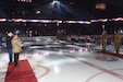 U.S. Army Reserve Lt. Col. Joseph Shalosky, left, renders a salute during the playing of the National Anthem at a Chicago Wolves military recognition game, March 11, 2023.