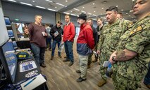 Milan Anderson, left, NSS-SY waterfront pillar representative, outlines current improvement initiatives for Sailors assigned to USS Pennsylvania (SSBN 735) and Puget Sound Naval Shipyard & Intermediate Maintenance Facility personnel during an Integrated Project Team Development Expo March 2, 2023, at the Kitsap Conference Center in downtown Bremerton, Washington. (U.S. Navy photo by Scott Hansen)
