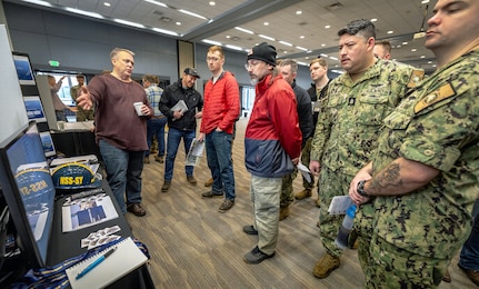 Milan Anderson, left, NSS-SY waterfront pillar representative, outlines current improvement initiatives for Sailors assigned to USS Pennsylvania (SSBN 735) and Puget Sound Naval Shipyard & Intermediate Maintenance Facility personnel during an Integrated Project Team Development Expo March 2, 2023, at the Kitsap Conference Center in downtown Bremerton, Washington. (U.S. Navy photo by Scott Hansen)
