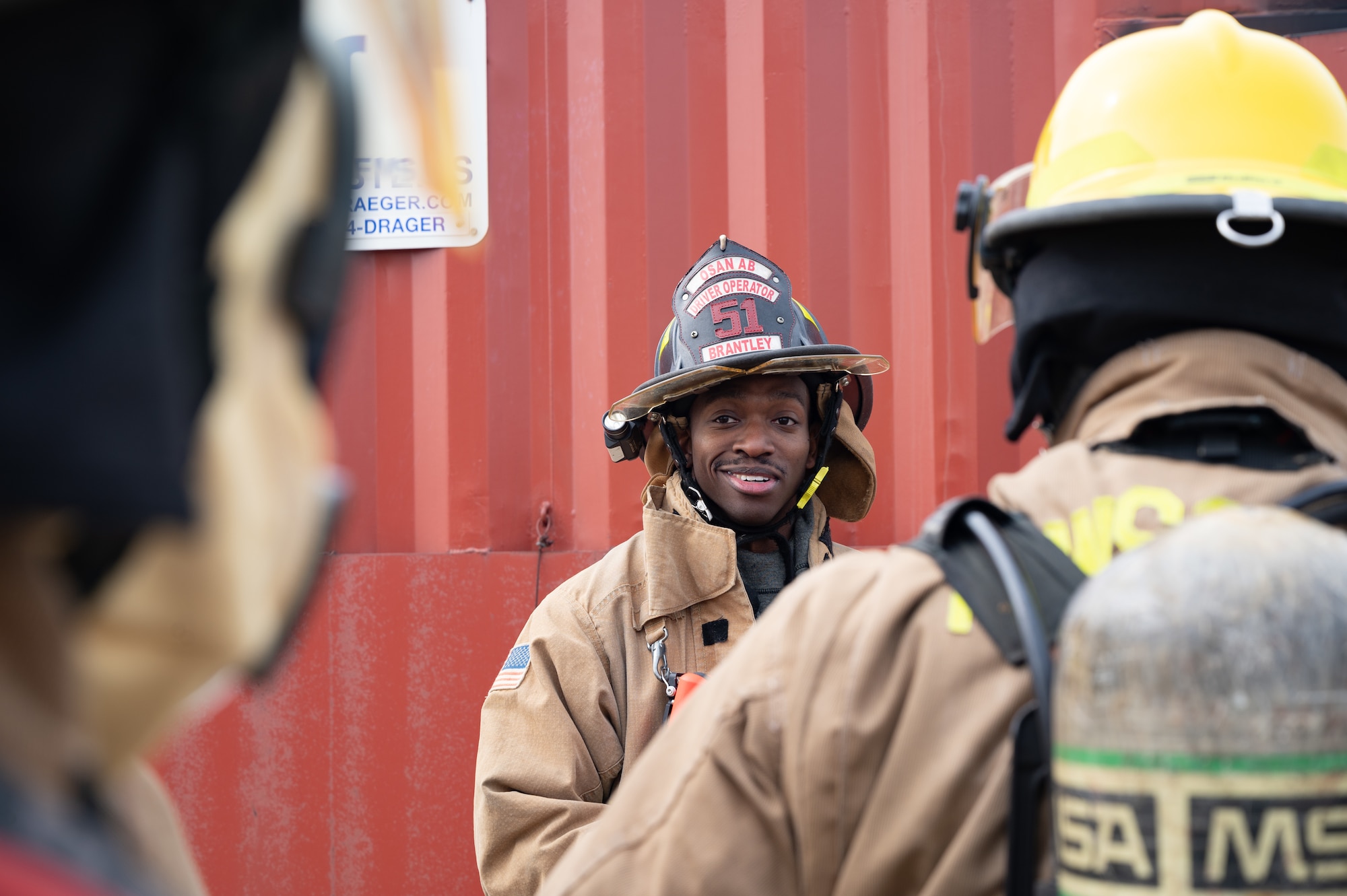 U.S. Air Force Senior Airman Charles Nettles III, 8th Civil Engineer Squadron firefighter, smiles during a joint training with U.S. Marine Corps firefighters at Kunsan Air Base, Republic of Korea, Mar. 9, 2023. The Airmen and Marines split into teams and rotated through different scenarios several times to enhance their performance. (U.S. Air Force photo by Staff Sgt. Sadie Colbert)