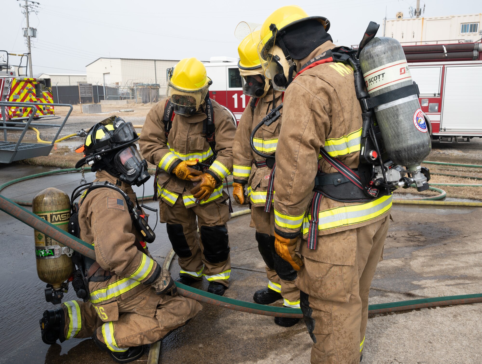 U.S. Air Force Staff Sgt. Charles Rogers (left), 8th Civil Engineer Squadron firefighter, instructs three U.S. Marine Corps Marine Wing Support Squadron 172 firefighters at Kunsan Air Base,
Republic of Korea, Mar. 9, 2023. Firefighters from the two services worked together to put out controlled, structural fires rated as class A burnings with one training scenario as a house fire and the other a larger building fire caused by propane. (U.S. Air Force photo by Staff Sgt. Sadie Colbert)