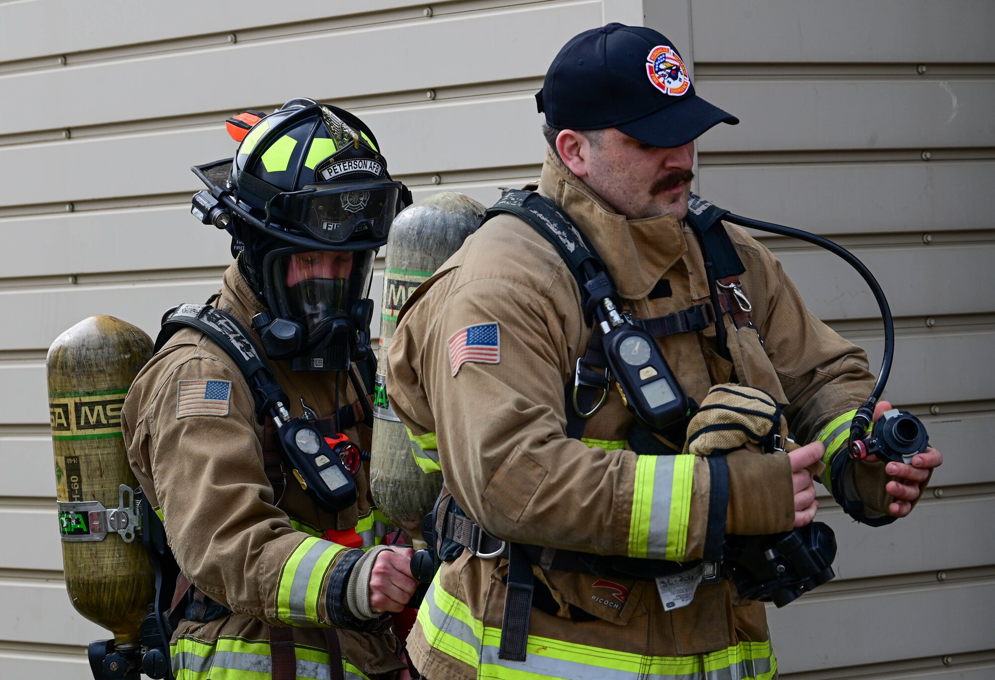 U.S. Air Force Staff Sgt. Charles Rogers (left), and Staff Sgt. Bobby Arguelles, 8th Civil Engineer Squadron firefighters, put on their fire suits during a joint training event. Proper maintenance and set up of personal protective equipment, such as a breathing apparatus, is essential to ensuring personnel safety. (U.S. Air Force photo by Senior Airman Shannon Braaten)