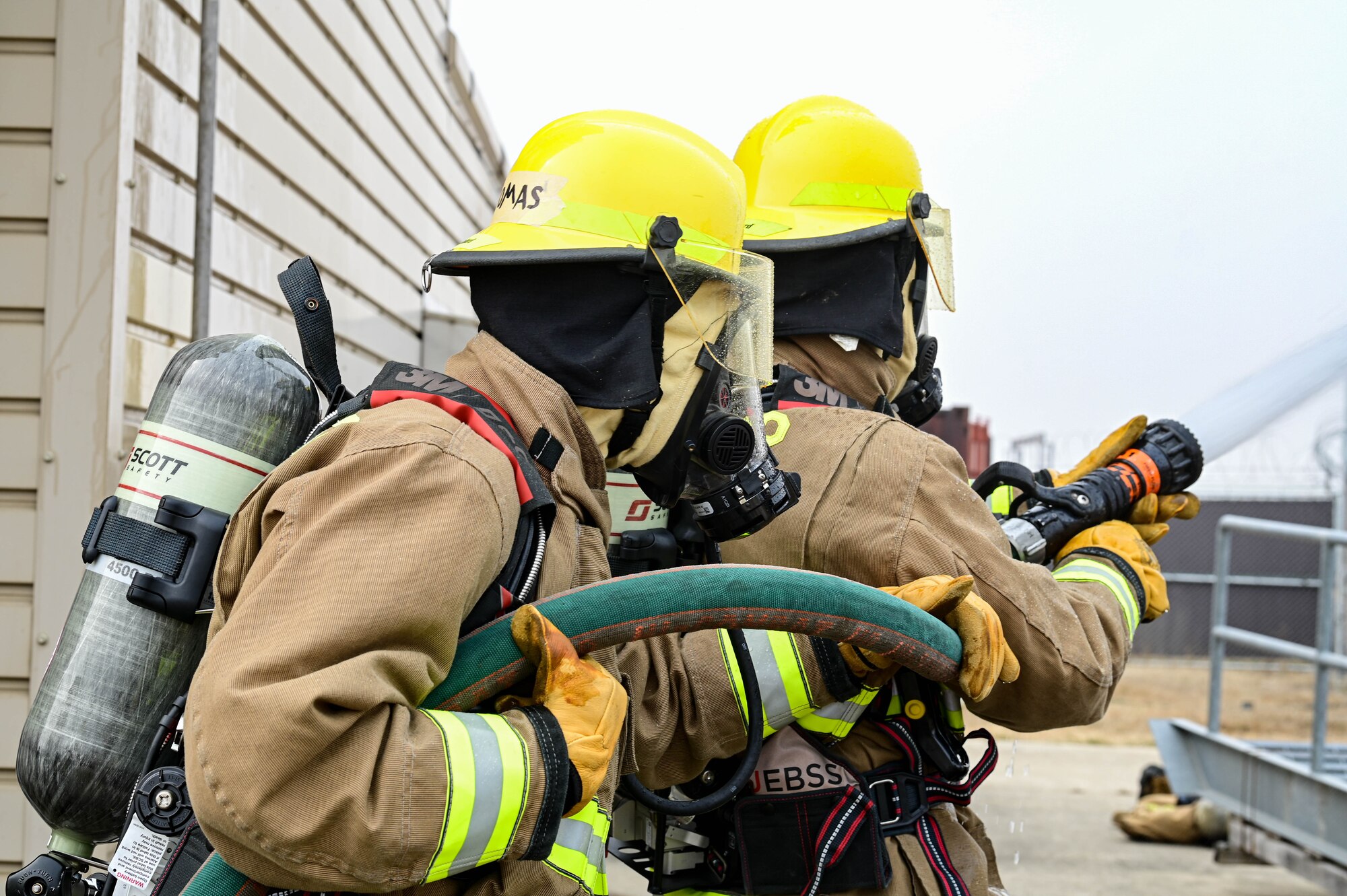 Firefighters from Marine Wing Support Squadron 172, Camp Foster, Japan, test a firehose’s water pressure during a joint training event at Kunsan Air Base, Republic of Korea, Mar. 9, 2023. Due to the high force of water ejecting from the hose, a minimum of two personnel are required to hold and control the flow of water. (U.S. Air Force photo by Senior Airman Shannon Braaten)