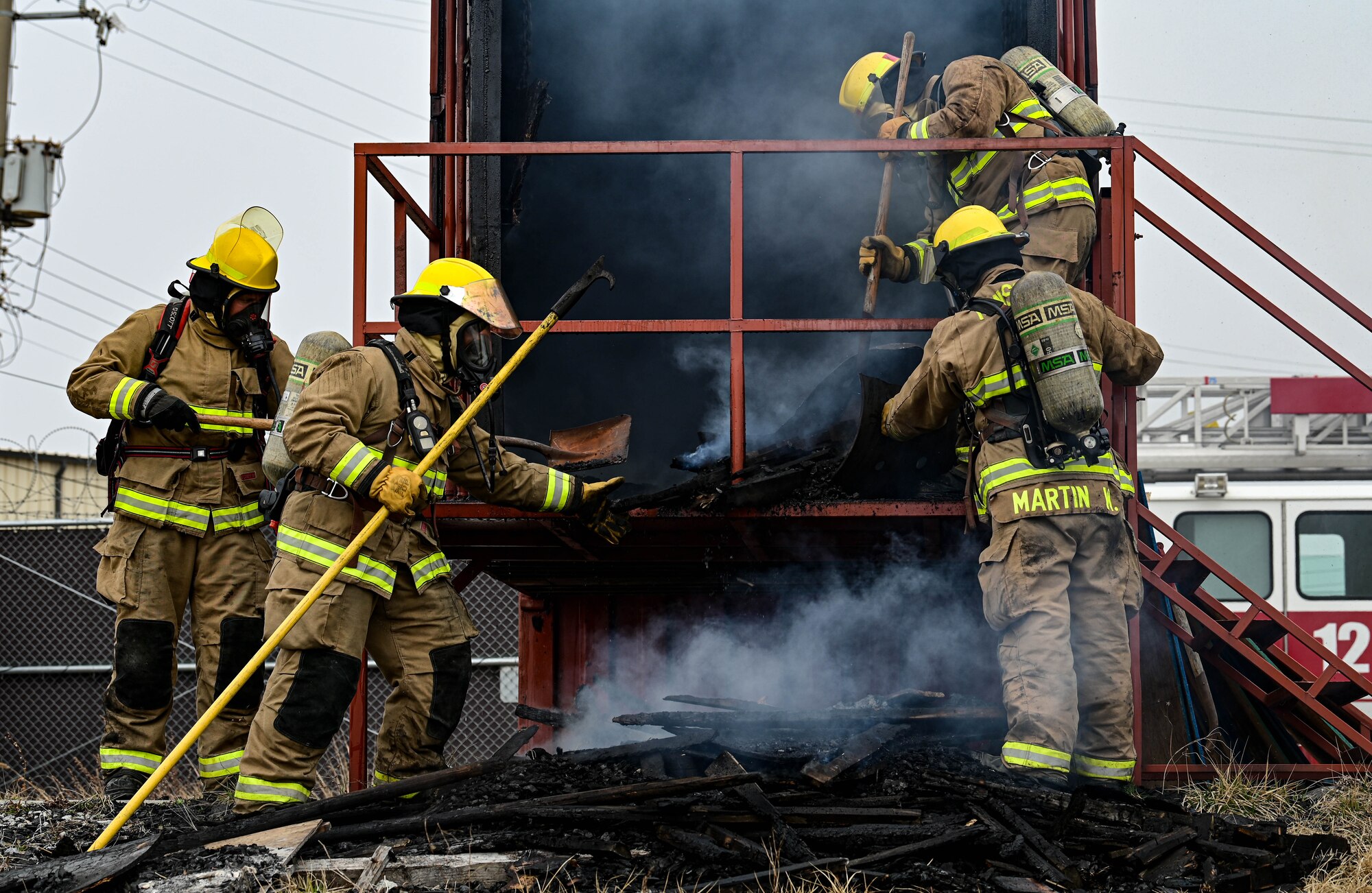 Firefighters from the U.S. Air Force 8th Civil Engineer Squadron and U.S. Marine Corps Marine Wing Support Squadron 172, Camp Foster, Okinawa, Japan, remove smoking materials from a burn house during a joint training event at Kunsan Air Base, Republic of Korea, Mar. 9, 2023. After each successful simulation, firefighters reset the scene with new material for the next training group. (U.S. Air Force photo by Senior Airman Shannon Braaten)