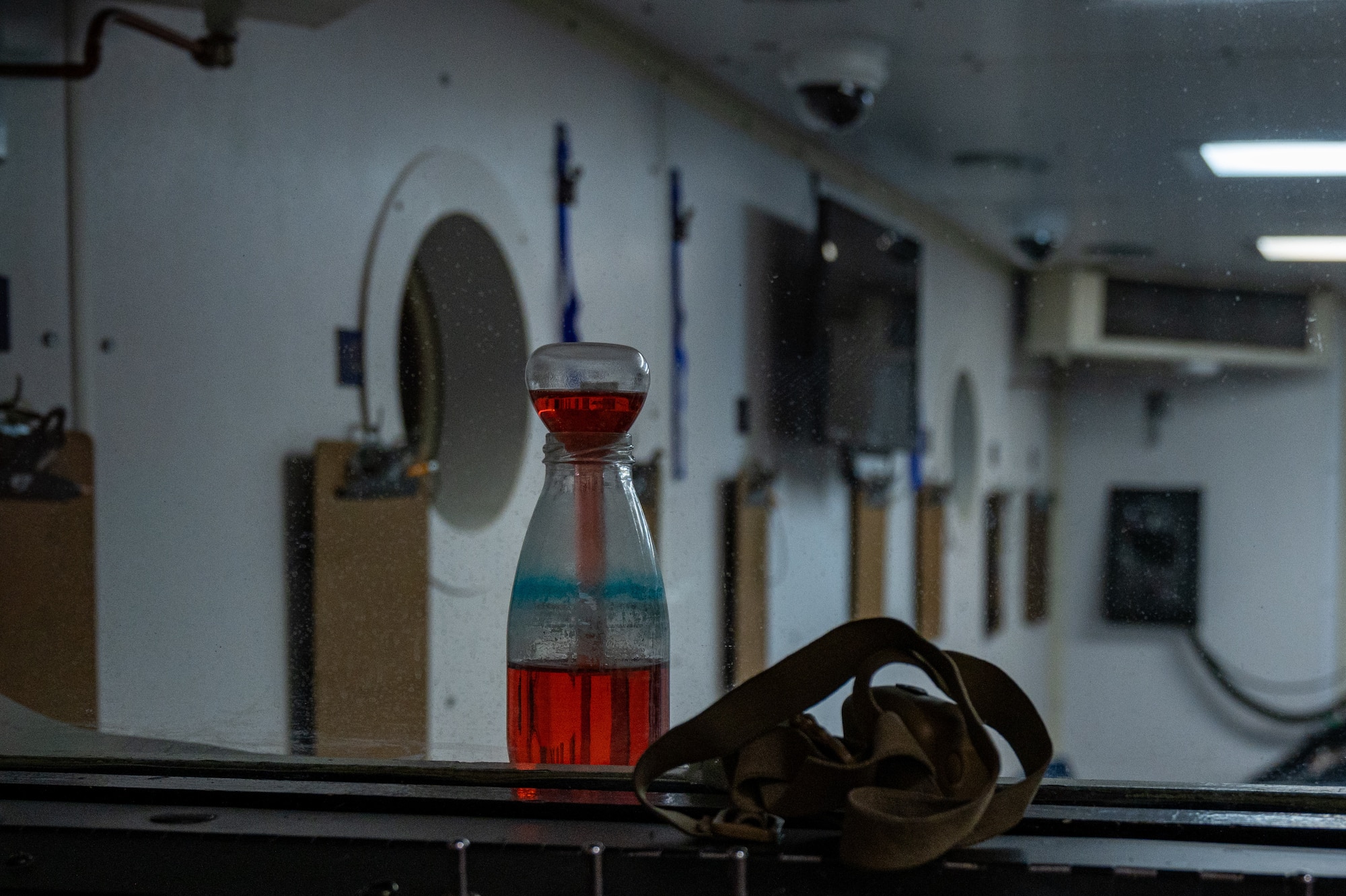 A breaker and flask sits on the control panel of an altitude chamber at Laughlin Air Force Base, Texas, on Feb. 24, 2023. Its purpose is to demonstrate what happens in your gastrointestinal tract when you ascend altitude. (U.S. Air Force photo by Senior Airman David Phaff)