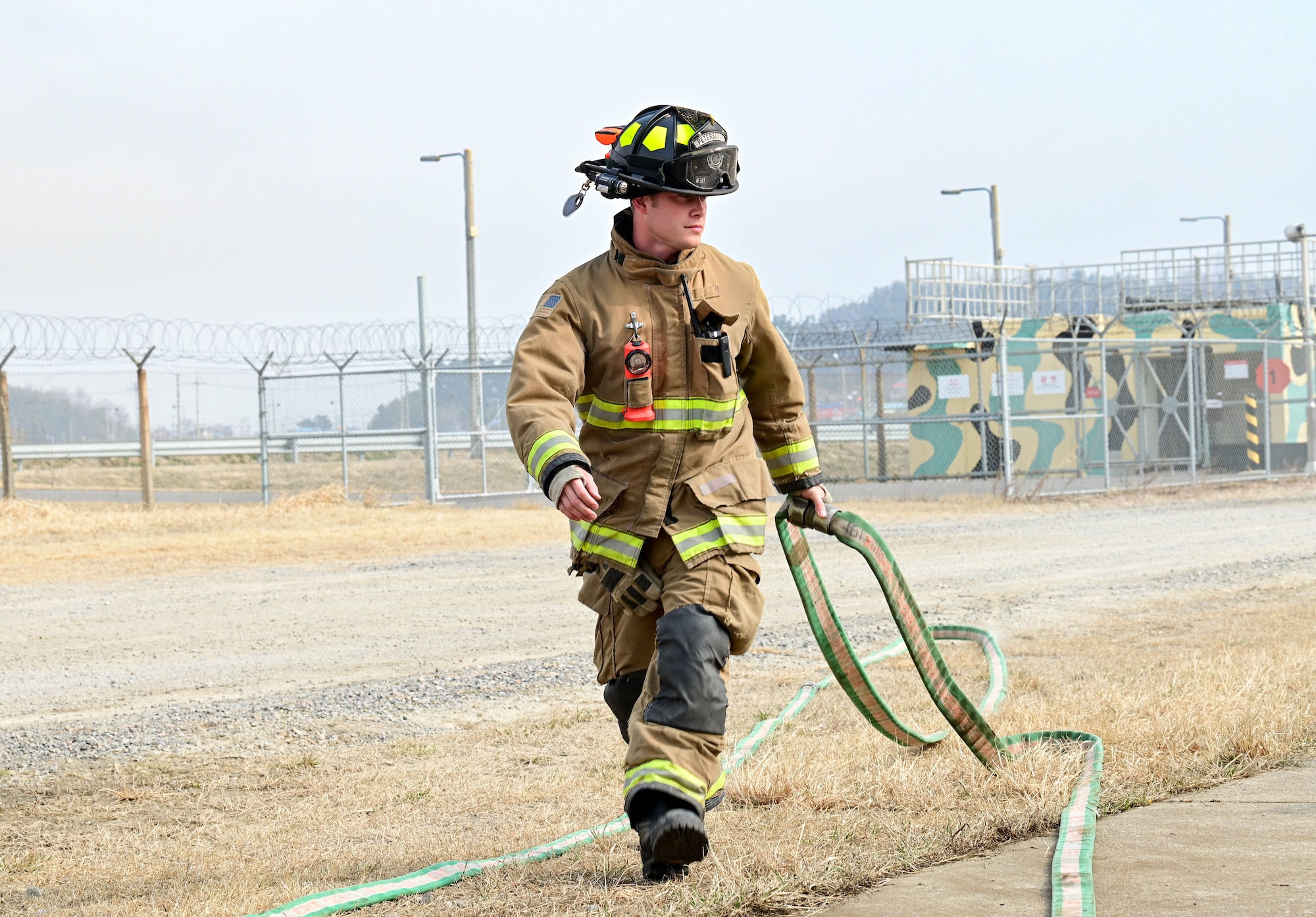 U.S. Air Force Staff Sgt. Charles Rogers III, 8th Civil Engineer Squadron firefighter, pulls a firehose into position during a joint training exercise at Kunsan Air Base, Republic of Korea Mar. 9, 2023. To maintain their emergency response readiness, firefighters routinely train for various situations and scenarios. (U.S. Air Force photo by Senior Airman Shannon Braaten)