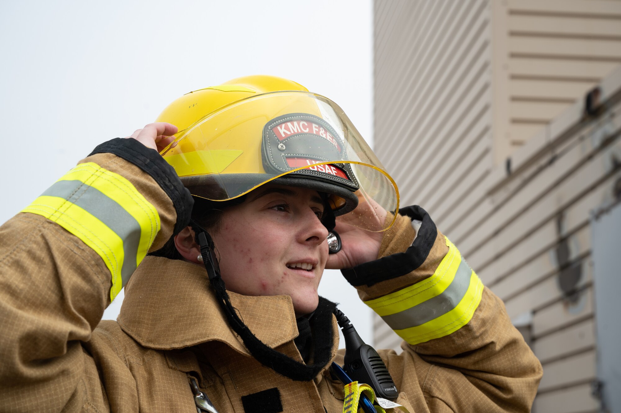 U.S. Air Force Senior Airman Hannah Menard, 8th Civil Engineer Squadron firefighter, dons a helmet at Kunsan Air Base, Republic of Korea, Mar. 9, 2023. The 8th CES fire services flight spends several hours training to respond to various scenarios to ensure they can safely contain fires and save lives. (U.S. Air Force photo by Staff Sgt. Sadie Colbert)