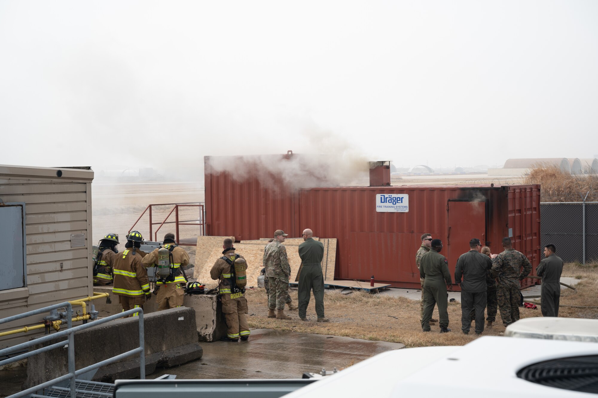 Firefighters with the U.S. Air Force 8th Civil Engineer Squadron and U.S. Marine Corps Marine Wing Support Squadron 172 stand by for training at Kunsan Air Base, Republic of Korea, Mar. 9, 2023. Joint training enables service members to learn from each other and refine or add skills and capabilities, ensuring they provide quality aid when responding to various incidents. (U.S. Air Force photo by Staff Sgt. Sadie Colbert)