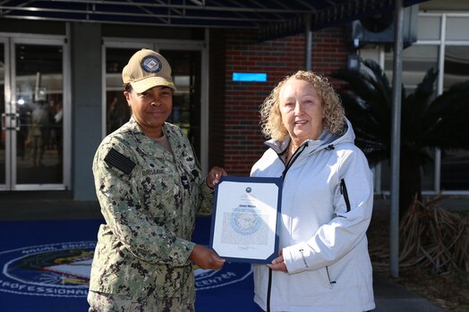  230314-N-YR423-5833 PENSACOLA, Fla. (March 14) - Naval Education and Training Professional Development Center (NETPDC) Commanding Officer Capt. Willie Brisbane presents Teresa Masseo with the senior Civilian of the Quarter (COQ) award for fourth quarter, 2022. Masseo's selection was based on her superior performance while serving the command’s administrative and security divisions. (U.S. Navy photo by Cheryl Dengler)