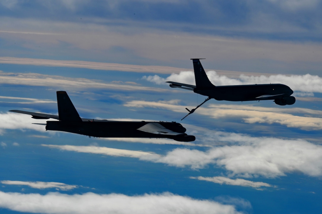 An aircraft is refueled by another aircraft in midair.