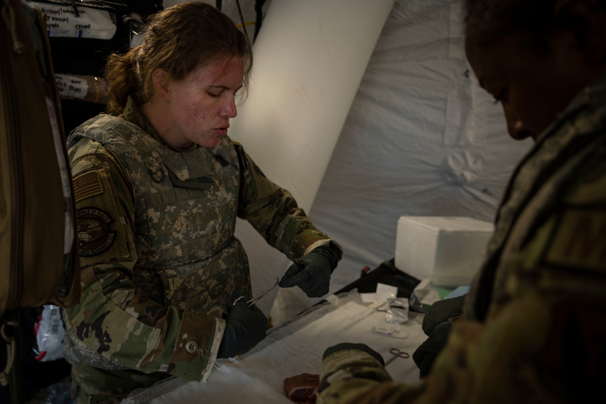 Capt. Karen Rodriguez, left, 4th Operational Medical Readiness Squadron flight doctor teaches Maj. Early Rice, 4th Medical Group nurse, how to administer sutures during Agile Cub 4 at Marine Corps Air Station Cherry Point, North Carolina, March 7, 2023. This agile combat employment exercise shifts the generation of airpower from large, centralized bases to networks of smaller, dispersed locations.