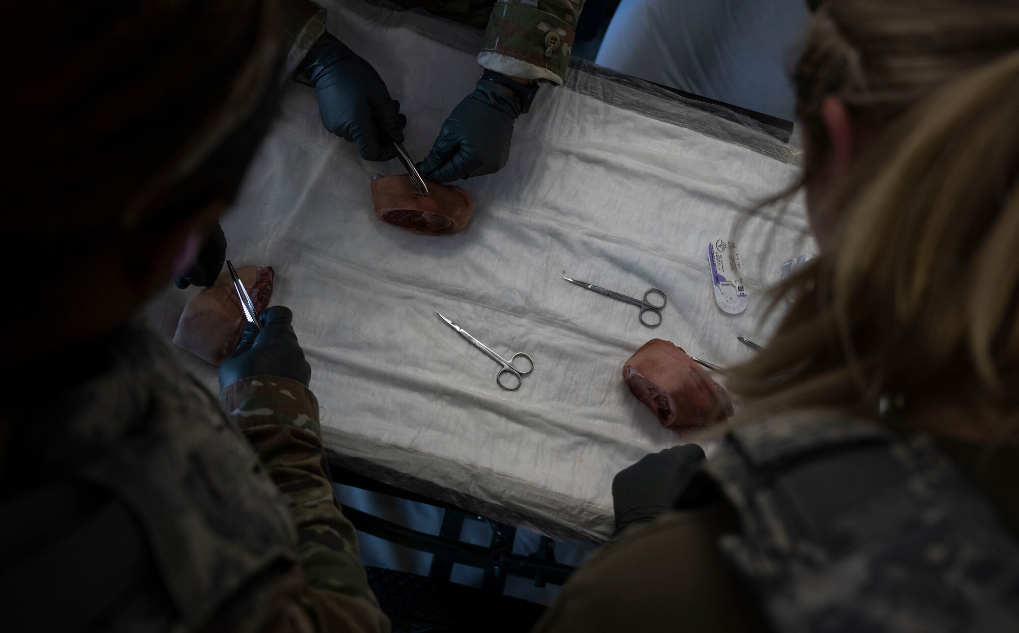 Airmen assigned to the 4th Medical Group practice administering sutures during Exercise Agile Cub 4 at Marine Corps Air Station Cherry Point, North Carolina, March 7, 2023. This agile combat employment exercise shifts the generation of airpower from large, centralized bases to networks of smaller, dispersed locations