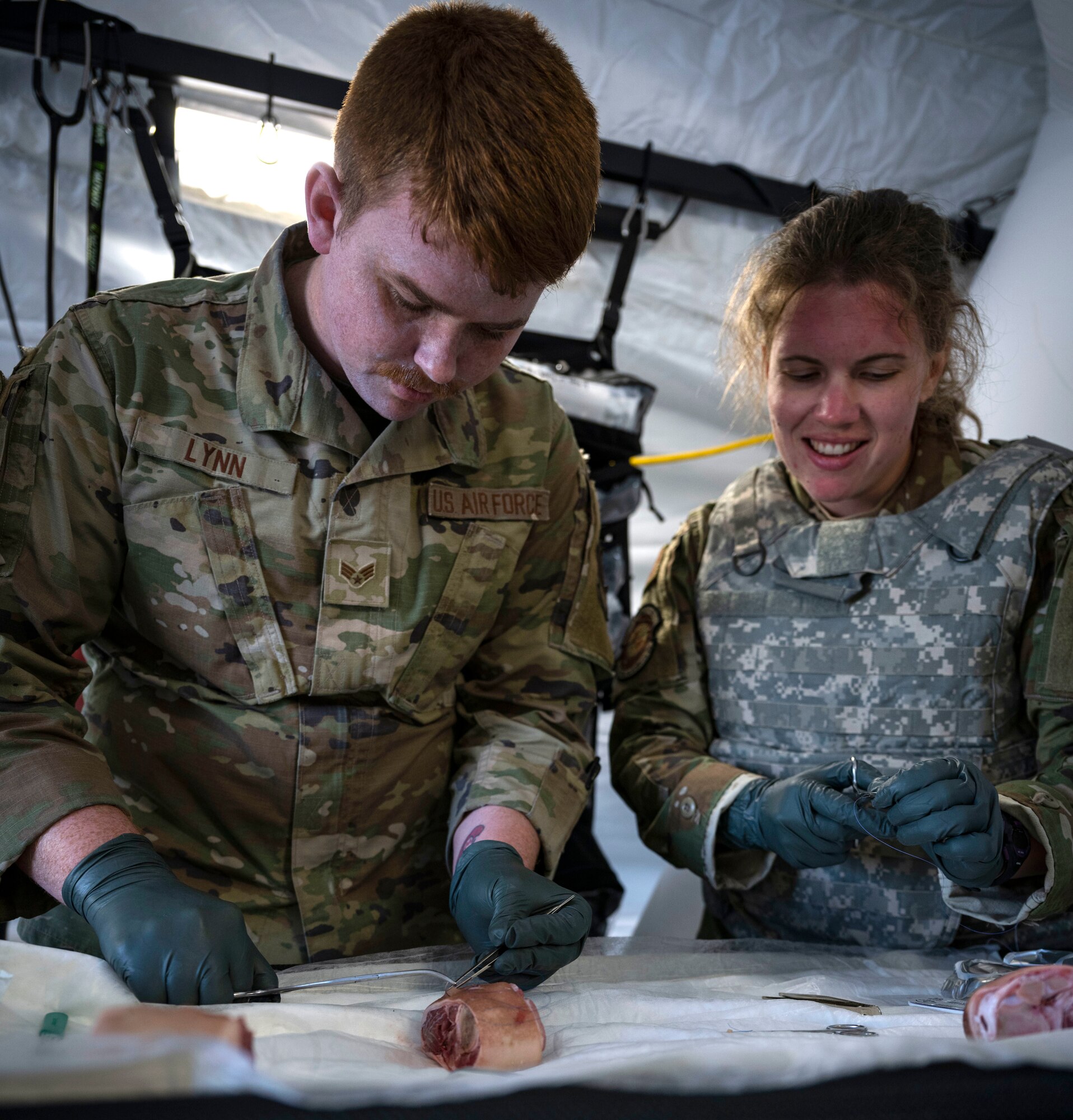 Capt. Karen Rodriguez, right, 4th Operational Medical Readiness Squadron flight doctor, teaches Senior Airman David Lynn, 4th Fighter Wing public affairs specialist, how to administer sutures during Agile Cub 4 at Marine Corps Air Station Cherry Point, North Carolina, March 7, 2023. This agile combat employment exercise shifts the generation of airpower from large, centralized bases to networks of smaller, dispersed locations.
