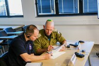 An Israeli translator explains the Commander's Course on Incident Command System to Sgt. 1st Class Nicholas Allee with the 7th CST, December 5, 2022