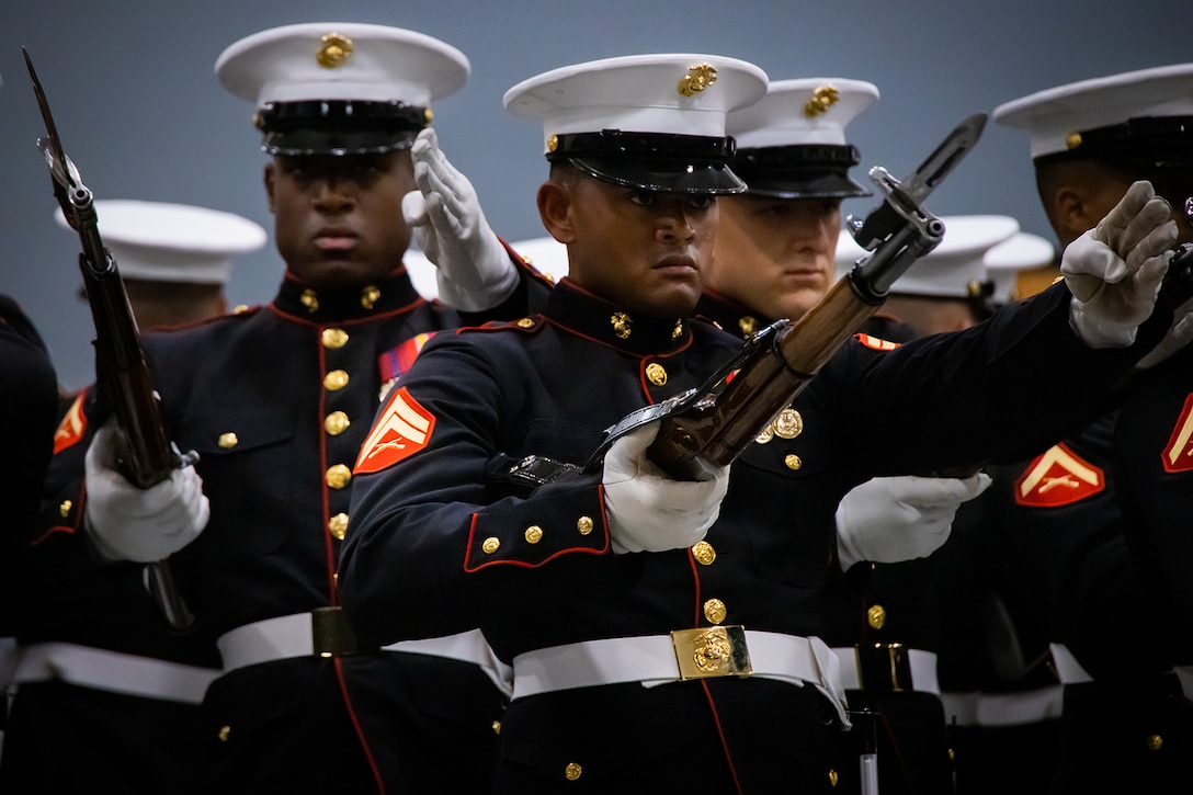 Silent drill platoon Marines pose in formation with their ceremonial weapons.