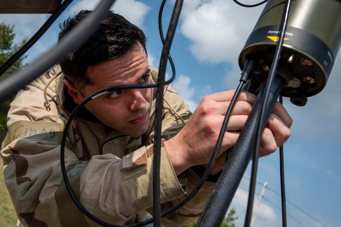 An airman is shown close-up, handling weather equipment.