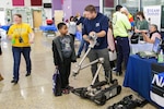 Daniel Swick, a robotics technician in NSWC IHD’s Unmanned Systems Branch, describes the explosive ordnance disposal functions of an iRobot Packbot during the History, Industry, Technology, and Science Expo at St. Charles High School in Waldorf, Maryland, March 11.