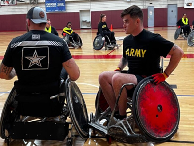 Assistant Wheelchair Rugby Coach Ross Alewine shows Spc. Colin Matthews a blocking technique for safety at the goal line.