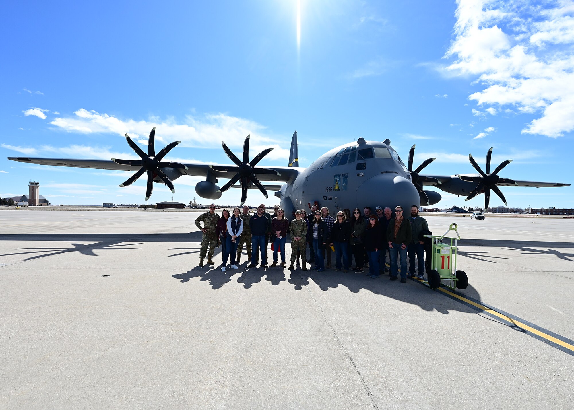 group posed in front of a helicopter