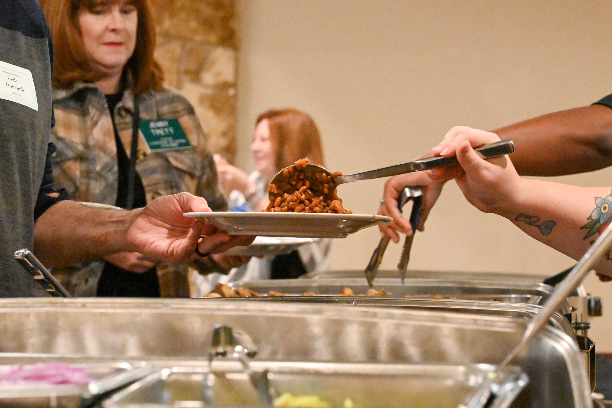 Airmen from the 97th Force Support Squadron serve food to members of Leadership Oklahoma during a luncheon at Altus Air Force Base, Oklahoma, March 14, 2023. Members of Leadership Oklahoma regularly participate in “Lunch and Learn” sessions across the state to encourage education, discussions, and problem solving with different industries. (U.S. Air Force photo by Senior Airman Trenton Jancze)