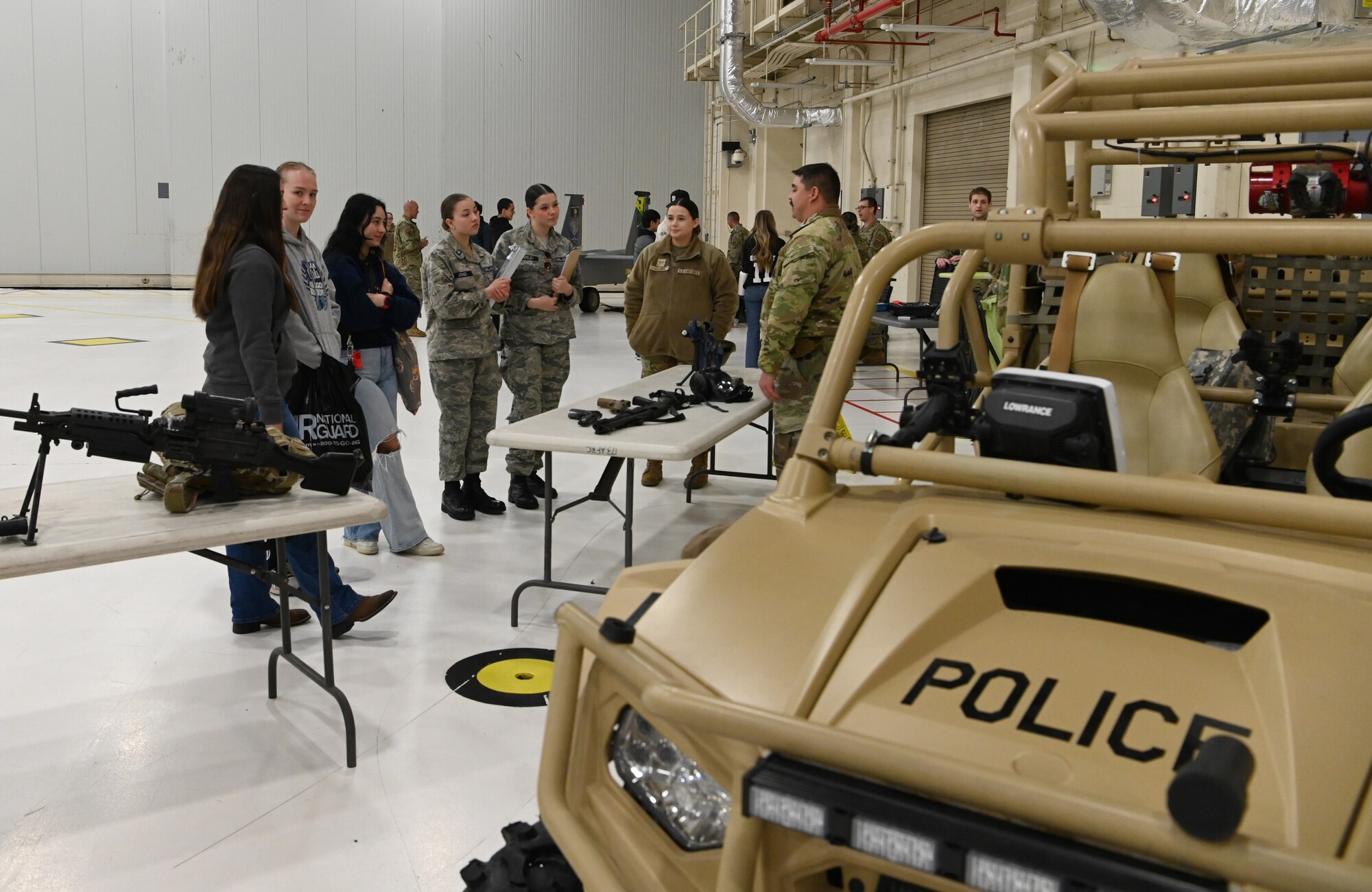 high school students look at military equipment
