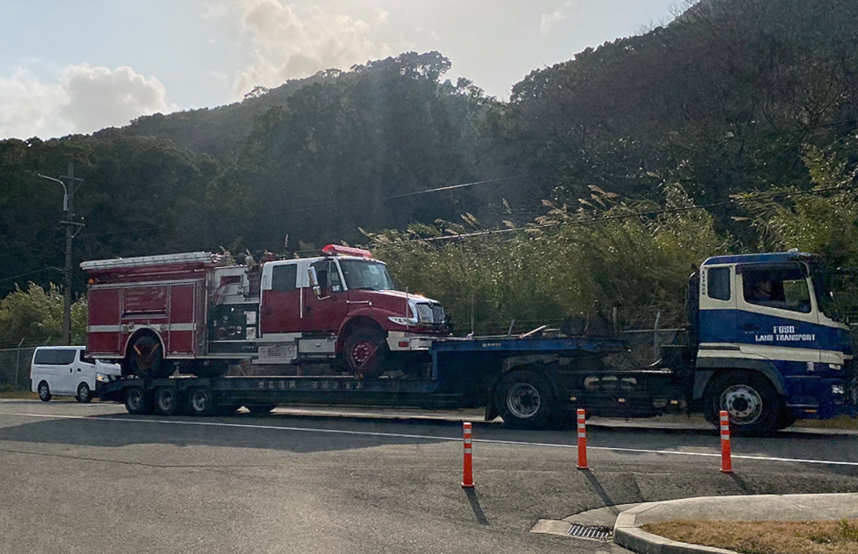 A firetruck is pulled on a semi-truck.