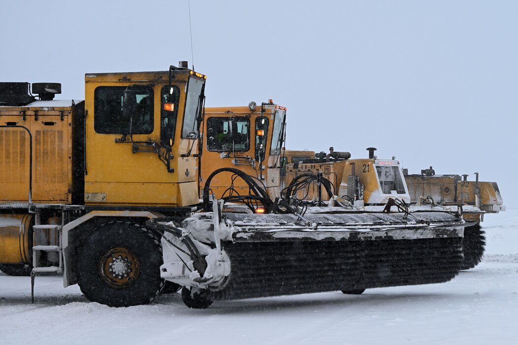 U.S. Air Force Airmen assigned to the 354th Civil Engineer Squadron wait in snow brooms on the flight line at Eielson Air Force Base, Alaska, Jan. 23, 2023.
