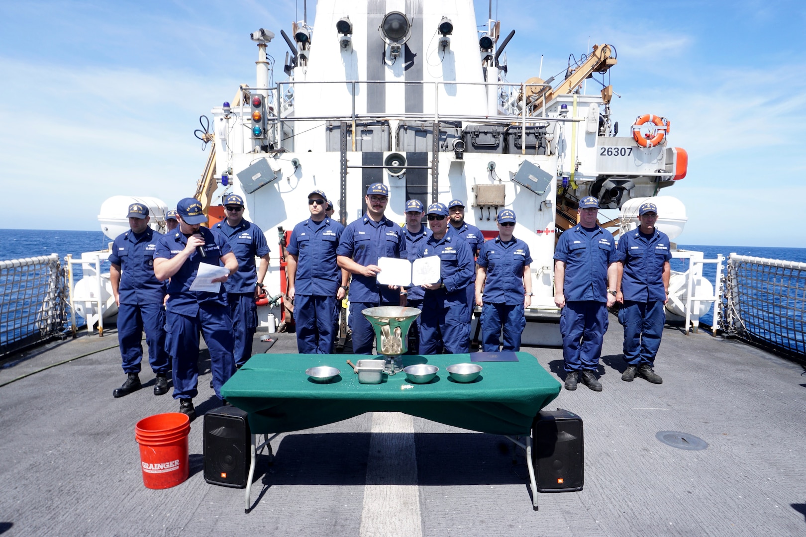 Petty Officer 2nd Class Calvin Richan poses with the Cmdr. Brock S. Eckel, Coast Guard Cutter Steadfast’s (WMEC 623) commanding officer, and fellow cutterman, during a cutterman ceremony where while Steadfast patrols the Eastern Pacific Ocean, March 6, 2023. Steadfast and crew returned to their Astoria, Oregon, homeport, March 14, 2023, following a 69-day counternarcotics patrol in the Eastern Pacific Ocean. U.S Coast Guard photo by Lt. j.g. DeLorie. U.S Coast Guard photo by Lt. j.g. DeLorie.