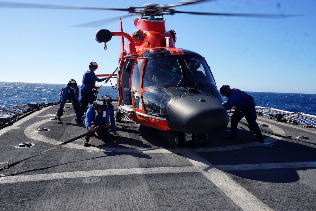 An MH-65 Dolphin helicopter and aircrew from the Helicopter Interdiction Tactical Squadron (HITRON) in Jacksonville, Florida, is secured to the Coast Guard Cutter Steadfast’s (WMEC 623) flight deck by the cutter’s tie-down crew while patrolling the Eastern Pacific Ocean, Feb. 19, 2023. The HITRON helicopter and aircrew deployed aboard the Steadfast during the cutter’s 69-day counternarcotics patrol. U.S. Coast Guard photo by Seaman Justin Gaudreau.