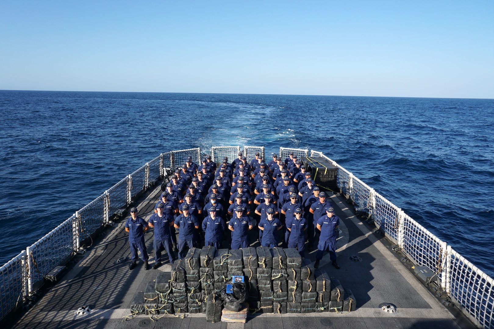 U.S. Coast Guard Cutter Steadfast’s (WMEC 623) crew stands in formation with 1,500 kilograms of cocaine valued at $37.5 million seized from suspected smugglers while patrolling the Eastern Pacific Ocean, March 4, 2023. Steadfast and crew returned to their Astoria, Oregon, homeport, March 14, 2023, following a 69-day counternarcotics patrol in the Eastern Pacific Ocean. U.S Coast Guard photo by Lt. j.g. Geoffrey DeLorie.