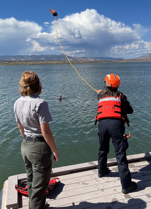 ABIQUIU LAKE, N.M. – Ranger Kara Rapp, left, teaches a member of the Abiquiu Volunteer Fire Department to toss a throw-bag to Ranger Jacklyn Rapport (in the water) during a joint rescue training at the lake, Sept. 25, 2022. Photo by Pamela Bowie.