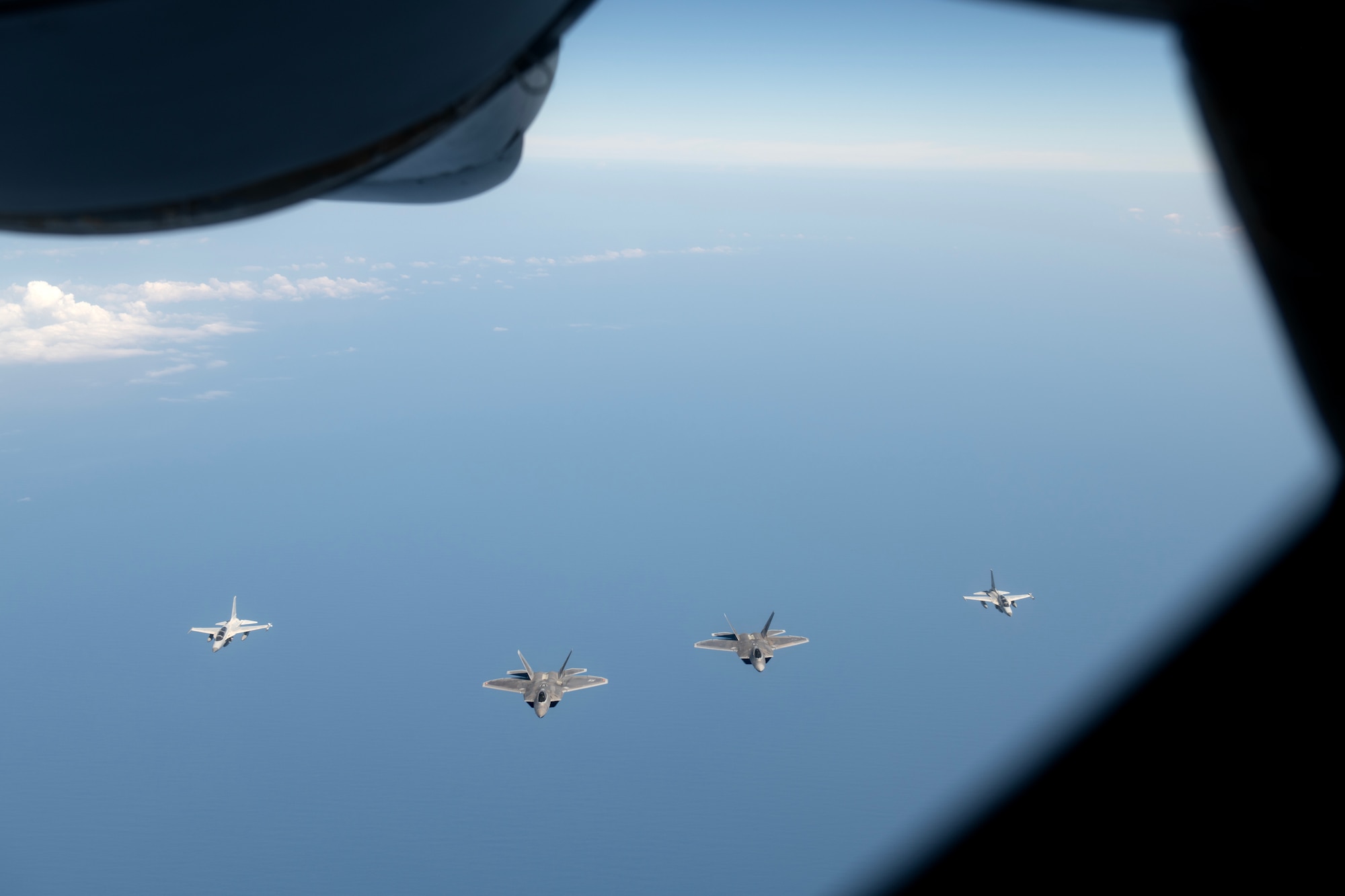 F-22A Raptors assigned to the 525th Fighter Squadron fly in formation with Philippine Air Force FA-50PH aircraft over the South China Sea, March 14, 2023. Integrating and training alongside the Philippine Air Force promotes interoperability, builds upon our strong alliance, and reaffirms the commitment to the Mutual Defense Treaty and maintaining peace and stability throughout the Indo-Pacific region. (U.S. Air Force photo by Senior Airman Jessi Roth)