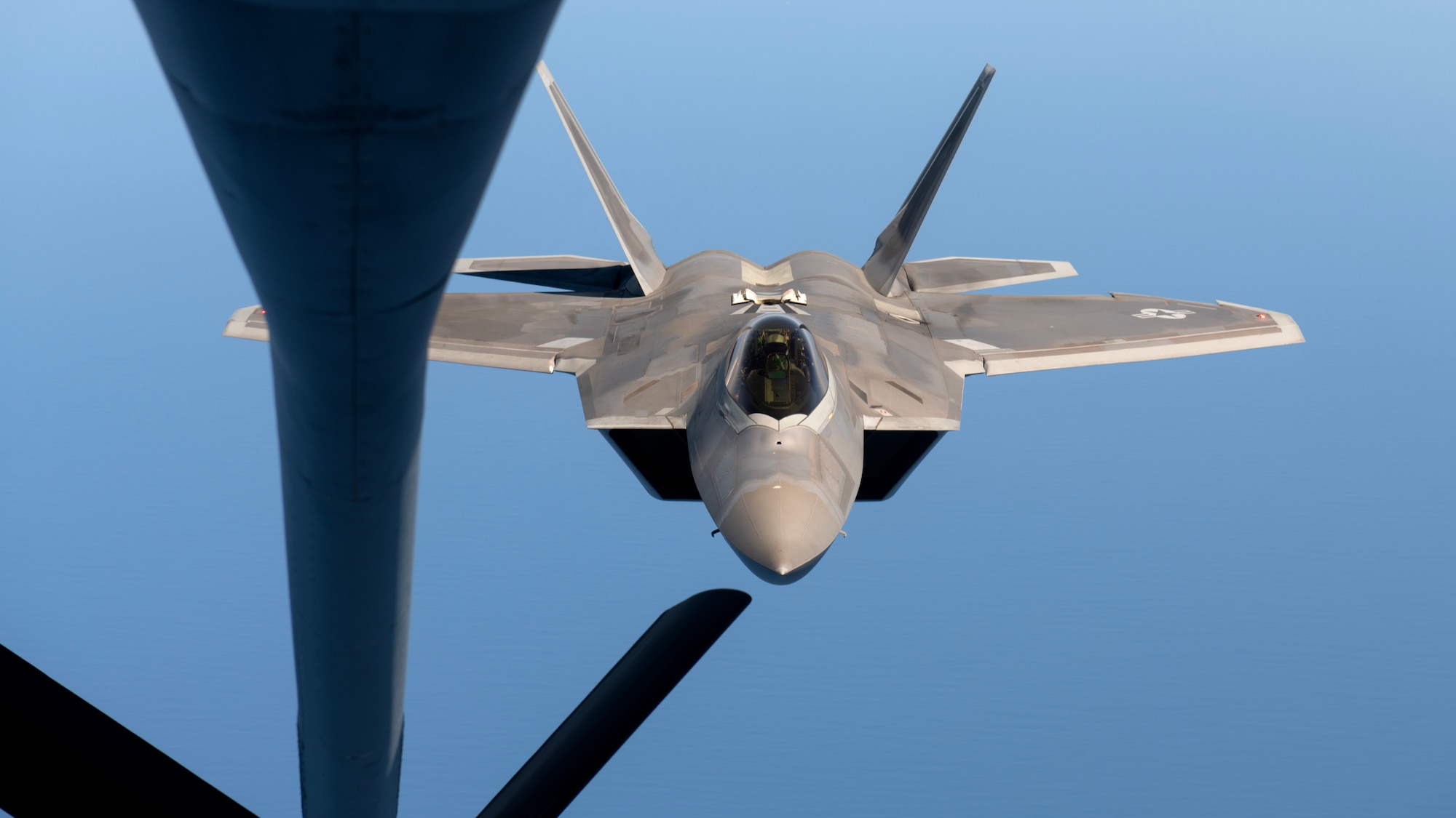 An F-22A Raptor assigned to the 525th Fighter Squadron flies approaches a KC-135 Stratotanker to receive aerial refueling over the South China Sea, March 14, 2023, in support of a bilateral training mission with the Philippine Air Force. Bilateral training and cooperation with our Philippine Air Force counterparts enhances the mutual readiness required to defend security, prosperity, and peace throughout the Indo-Pacific region. (U.S. Air Force photo by Senior Airman Jessi Roth)