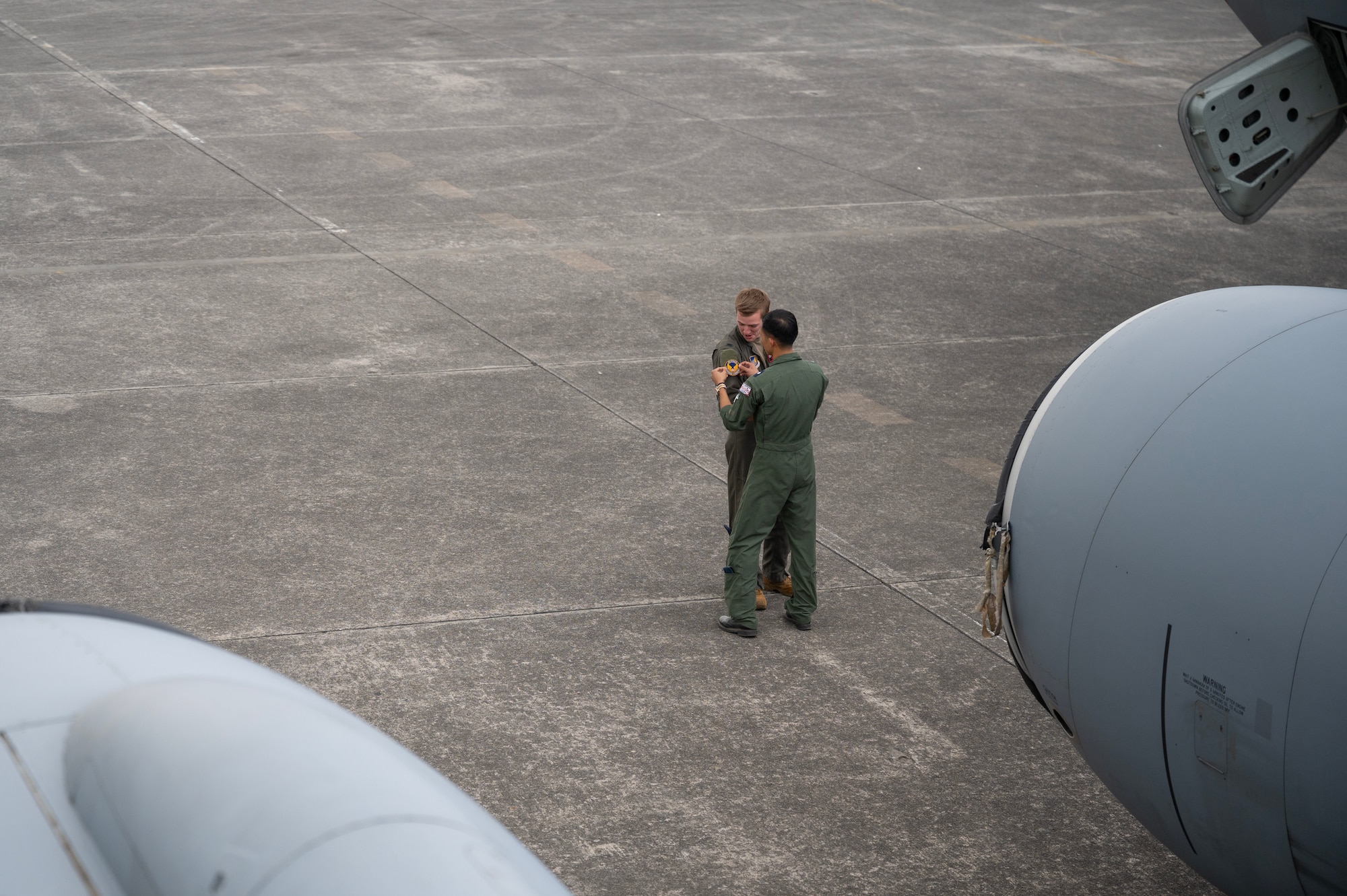U.S. Air Force 1st Lt. Samuel Bishop, 909th Air Refueling Squadron KC-135 Stratotanker pilot, swaps patches with a Philippine Air Force pilot at Clark Air Base, Philippines, March 13, 2023. The exchanging of patches is a long-standing military tradition and a symbolic gesture of respect and camaraderie. (U.S. Air Force photo by Senior Airman Jessi Roth)