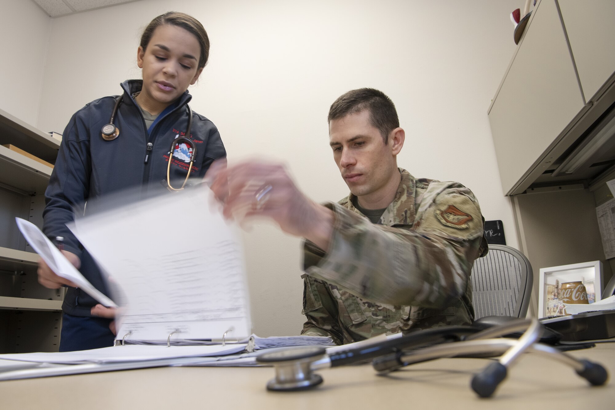 Airman 1st Class Jasmine Wilkerson (left), and Maj. Matthew Bezzant, (right), 374th Health Care Operations Squadron, review and discuss schedules at the Internal Medicine Clinic located at Yokota Air Base, Japan
