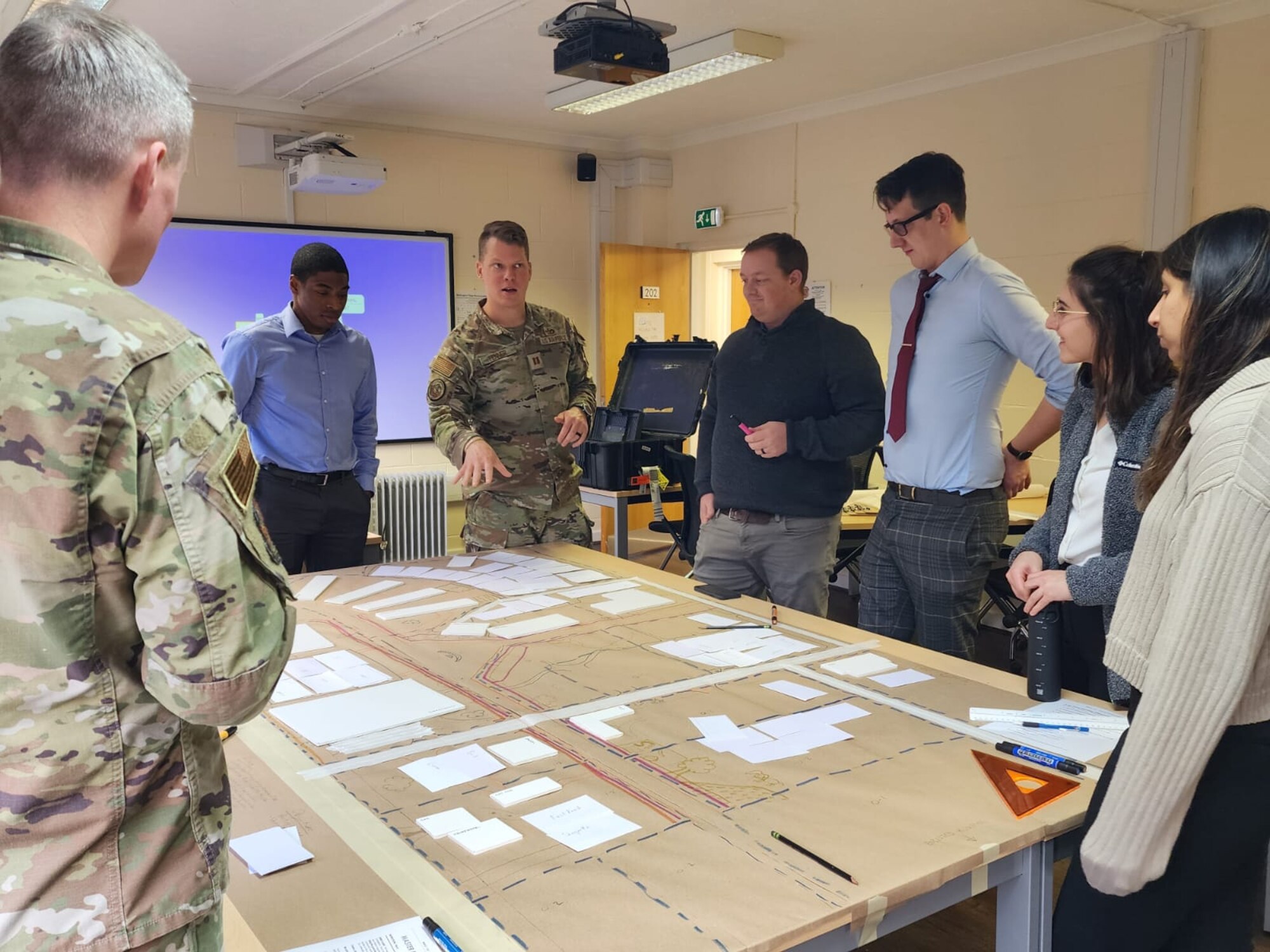 Capt. Andrew Fenner (center) talks with students about their real-world area-development plan for RAF Feltwell, England, as part of the first off-site offering of Air Force Institute of Technology Civil Engineer School’s Comprehensive Planning Course. (Contributed photo)