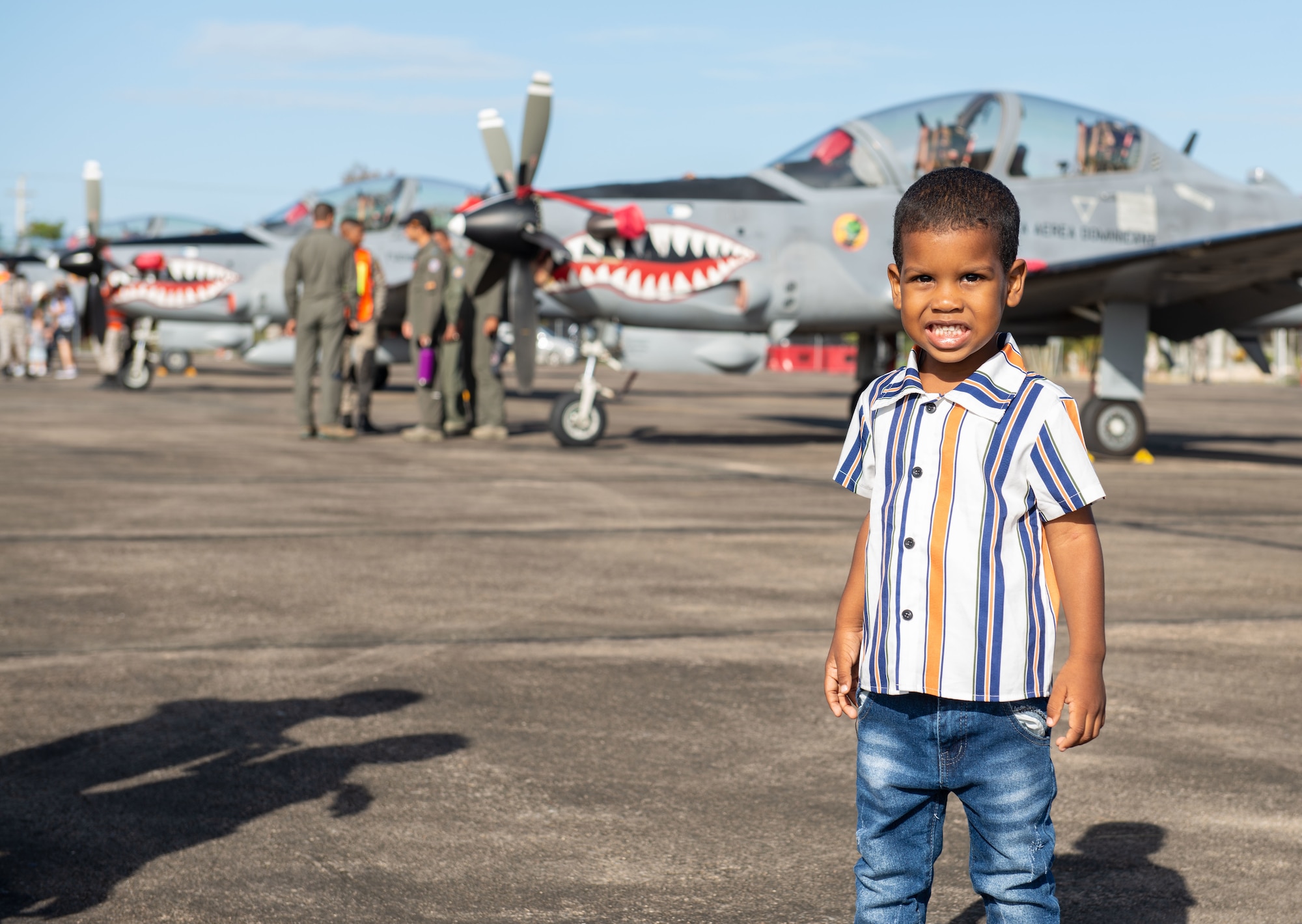 A boy poses for a photo during an airshow at San Isidro Air Base, Dominican Republic, Feb. 19, 2023.The airshow was dedicated to the Dominican Republic’s 75th anniversary where both U.S. and Dominican Republic aircraft demonstrated capabilities and strengthened their bond as partner nations.(U.S. Air Force photo by Tech. Sgt. Jessica H. Smith-McMahan)
