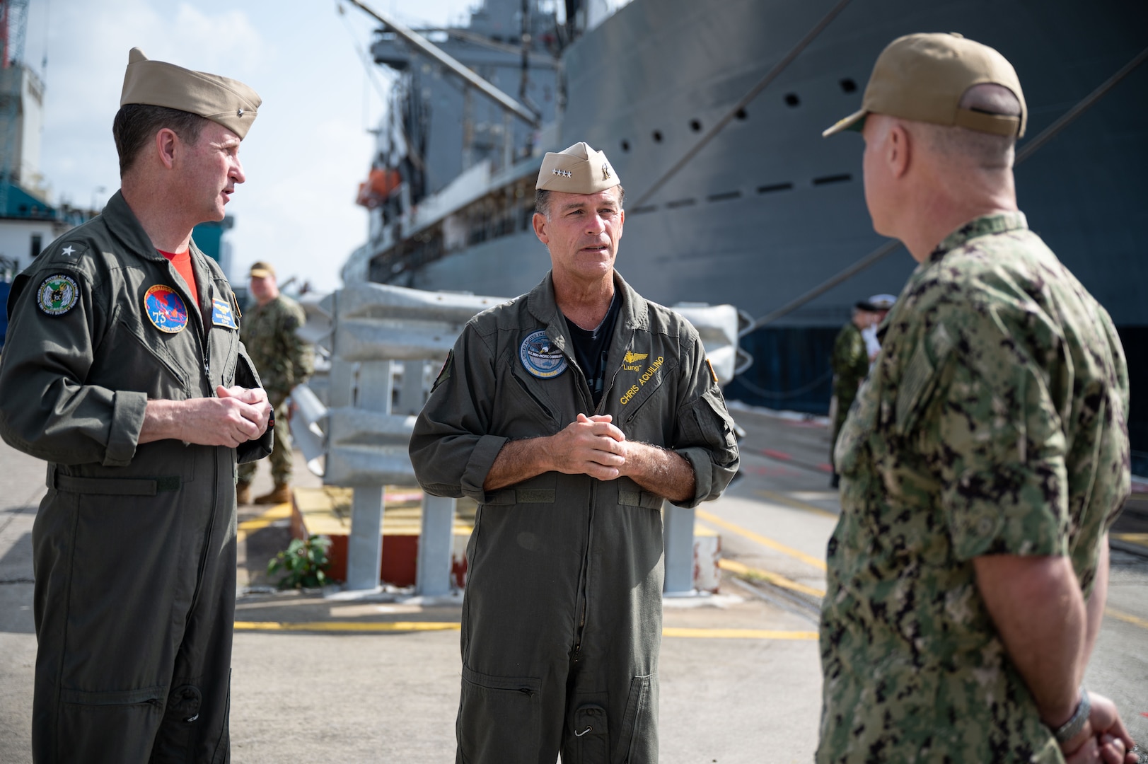 SINGAPORE (March 16, 2023) Rear Adm. Mark Melson, Commander, Logistics Group Western Pacific/ Task Force 73 (COMLOG WESTPAC/ CTF 73), left, gives a brief to Adm. John C. Aquilino, Commander U.S. Indo-Pacific Command, center, during an overseas trip to Singapore. COMLOG WESTPAC supports deployed surface units and aircraft carriers, along with regional Allies and partners, to facilitate patrols in the South China Sea, participation in naval exercises and responses to natural disasters. USINDOPACOM is committed to enhancing stability in the Asia-Pacific region by promoting security cooperation, encouraging peaceful development, responding to contingencies, deterring aggression and, when necessary, fighting to win. (U.S. Navy photo by Chief Mass Communication Specialist Shannon M. Smith)