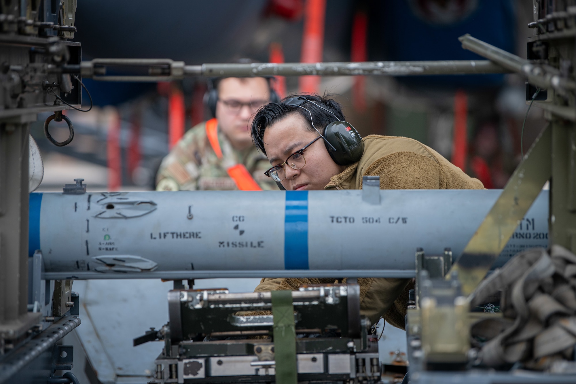Airman loads missiles onto an aircraft.