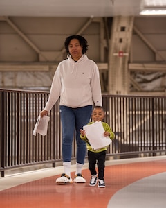 A woman and her child walks on the track
